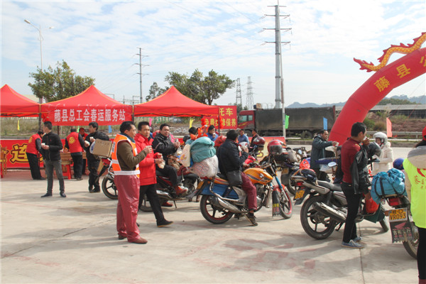 圖為藤縣總工會(huì)在省道304線藤縣陶瓷工業(yè)園區(qū)商業(yè)街小廣場(chǎng)設(shè)立藤縣總工會(huì)為農(nóng)民工平安返鄉(xiāng)“暖流行動(dòng)”服務(wù)站，積極為騎摩托車